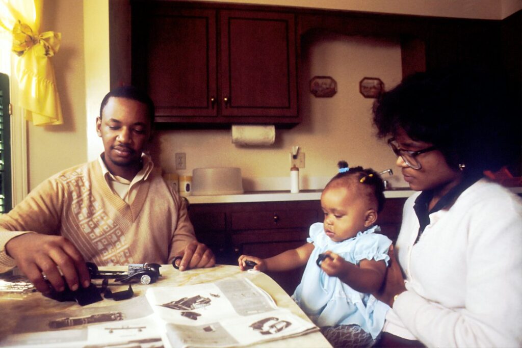 Parent and child review tax documents at a kitchen table beside a calculator.
