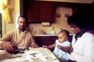 Parent and child review tax documents at a kitchen table beside a calculator.
